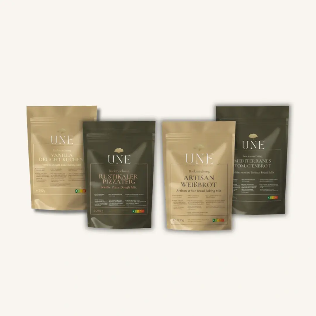 UNE Foods Kennenlern-Bundle mit vier ballaststoffreichen und proteinreichen Backmischungen: Vanilla Delight Cake, rustikaler Protein-Pizzateig, glutenfreies Artisan Weißbrot und mediterranes Tomatenbrot.