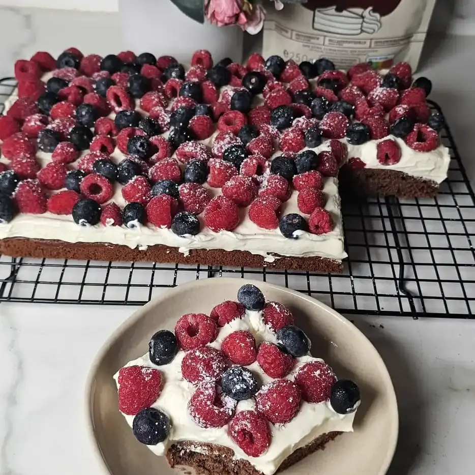 Proteinreicher Schokokuchen mit Pudding-Sahne-Creme und frischen Himbeeren & Heidelbeeren – glutenfrei, keto- freundlich und ballaststoffreich von UNE Foods.