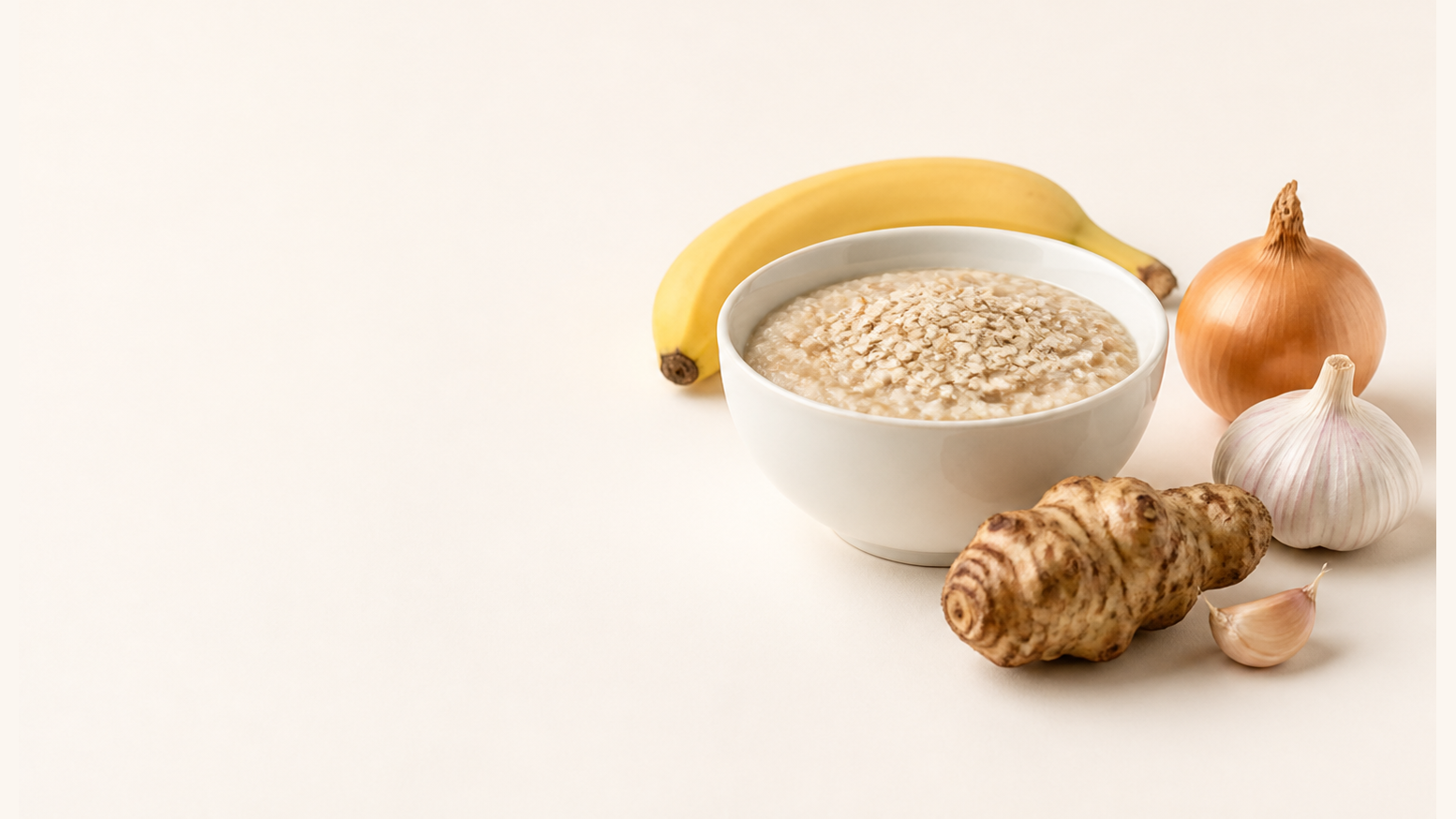 Präbiotische Lebensmittel: Bowl mit Haferflocken, Banane, Zwiebel, Topinambur und Knoblauch als natürliche Faserquellen