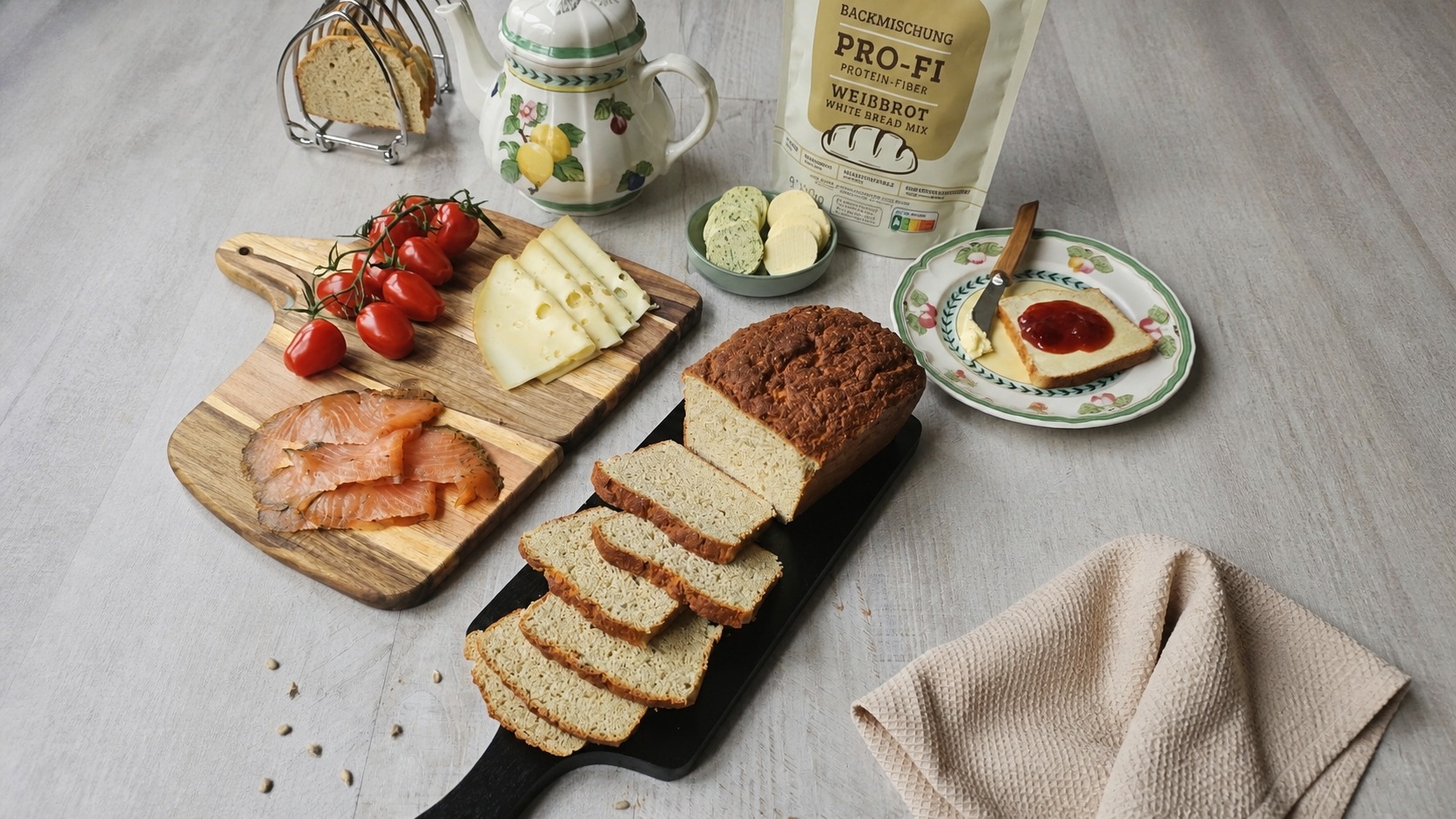 Frisch gebackenes Eiweißbrot in Scheiben mit Lachs, Käse, Tomaten und der glutenfreien UNE Foods Eiweißbrot-Backmischung